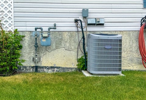 Outdoor air conditioning unit in a backyard on a concrete pad