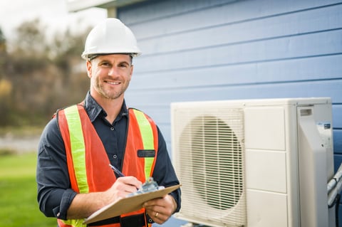 Technician working on heat pump outdoor unit